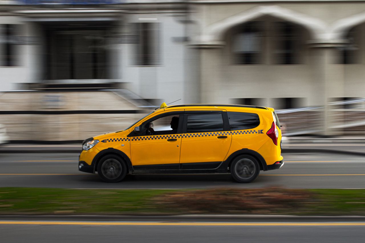 Mastering the First Impression: Your intriguing post title goes here A yellow taxi in motion on a city road, showcasing dynamic urban travel.