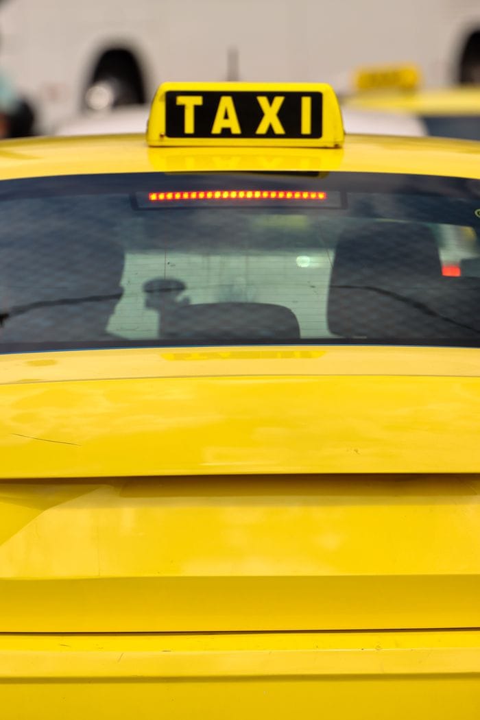 Crafting Captivating Headlines: Your awesome post title goes here Close-up of a yellow taxi in Athens, Greece, highlighting the bright sign and urban setting.